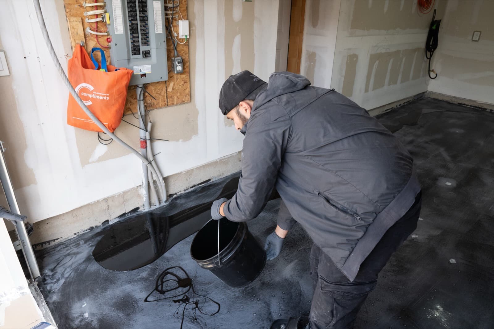 A LiquidLux installer spreading epoxy base coat across a prepared slab