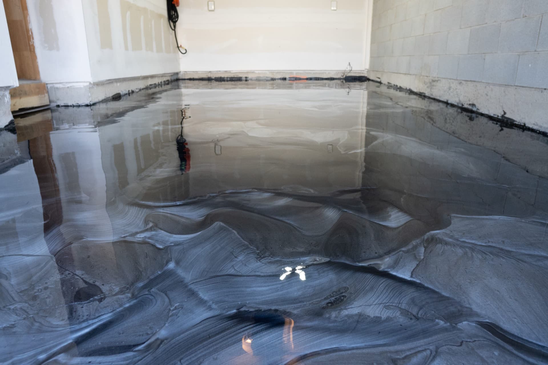 A finished LiquidLux metallic epoxy garage floor in Milton, reflecting the room like a mirror